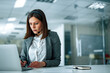 © bnenin - Concentrated woman in headset sitting at desk, looking at laptop and taking notes, portrait, copy space.