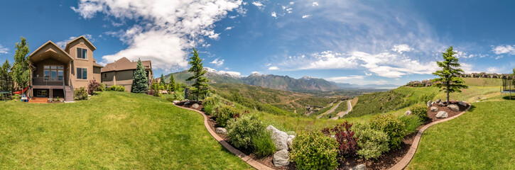 Wall Mural - Panorama of the backyard of home with landscaped grassy lawn and lush plants