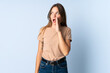 © luismolinero - Young Lithuanian woman isolated on blue background whispering something with surprise gesture while looking to the side
