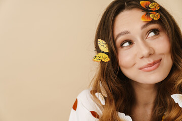 Wall Mural - Photo of joyful woman with fake butterflies smiling and looking aside