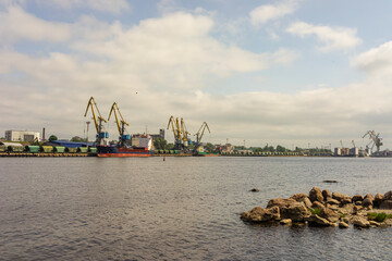 Panorama of the port cranes of ships. Railway cars on loading and unloading.