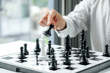 hand of businessman moving chess in competition, shows leadership, followers and business success strategies