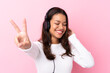 © luismolinero - Young woman with earphones over isolated pink wall