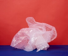 Crumpled Piece Of Polyethylene With Air Bubbles On A Blue Wooden Background