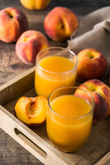 Sticker - Natural peach juice in glass on wooden table	