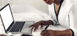 © Art_Photo - Young african american black woman relaxing and using laptop computer with white mockup blank screens.woman checking social apps and working.Communication and technology concept