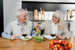 © LIGHTFIELD STUDIOS - happy senior wife and husband having dinner with wine and salad at home on quarantine