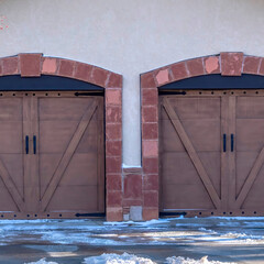 Square Facade of a residential garage with gable roof and two hinged wooden doors