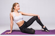 © dianagrytsku - Young fit woman sitting on the matt and relax on white background