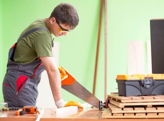 Wall Mural - Young man carpenter working in workshop