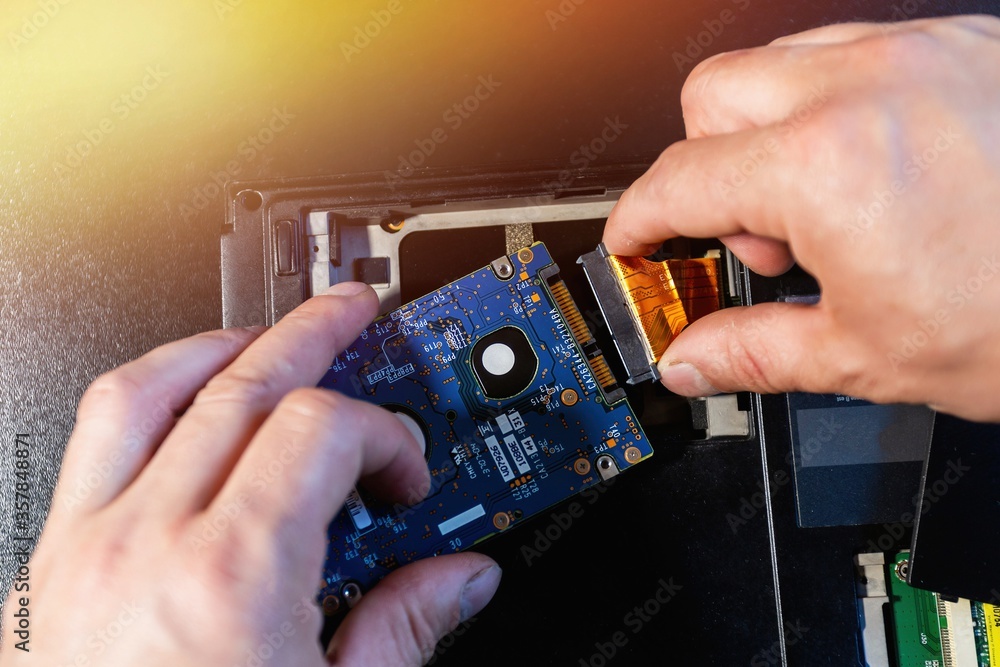 Replacing Computer Replacing or installing hdd on an old laptop, on a black background ...