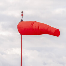 Square Crop Red Wind Sock At An Airport Blowing In The Wind