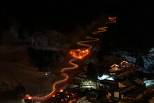 Night Long Exposure Shot Of Winter Ski Show. Skiers With Torches Sliding Down And Creating A Heart In The Middle Of The Slope. Santa Cristina. Val Gardena. Italy.