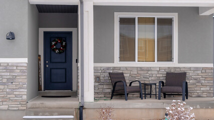 Wall Mural - Panorama crop Home facade with gable roof front porch and door with wreath in winter