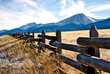 A ranch fence in Colorado with a mountain background.