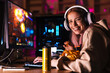 © Drobot Dean - Image of cheerful cute girl eating chips while playing video game