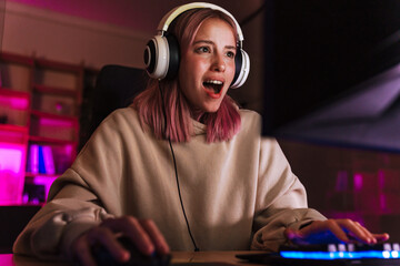 Wall Mural - Image of shocked girl in headphones playing video game on computer