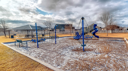 Wall Mural - Panorama Playground with remnants of snow on the ground under sky filled with clouds