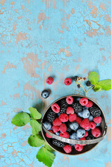 Poster - Berries raspberries, blueberries and blackberries in a silver basket on an old background. Place for text. Copy space. top view