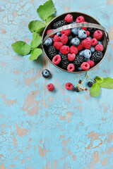 Sticker - Berries raspberries, blueberries and blackberries in a silver basket on an old background. Place for text. Copy space. top view