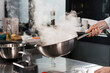 © stockbusters - Chef hands keep wok at professional kitchen. Closeup chef hands cook food.