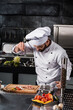 © stockbusters - Chef salt slice vegetables and meat. Concentrated chef prepare food.