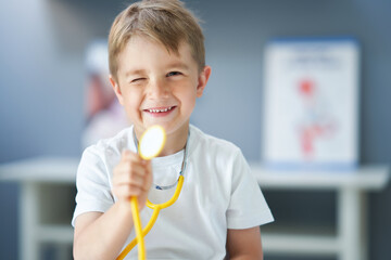 A little doctor with stethoscope smiling in doctor's office