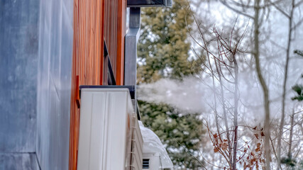 Panorama Exterior wall of home with air conditioning units and pipe blowing off steam