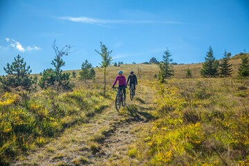 Poster - Woman and man tourists riding a bicycle in Karst, Slovenia