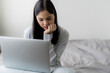 © Chanakon - Young beautiful woman works from home with laptop computer at the the bedroom, living room.Communication and video conference concept