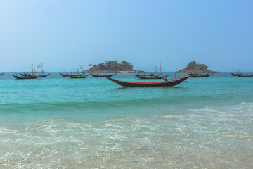 Wooden fishing boats in a small port. Beautiful landscape of sea, shore and boats. Tropical paradise turquoise water and sandy beach. Andaman Sea view. Summer holiday in tropical paradise.Burmese