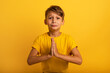 Child is pleading because he has something to request. Yellow background