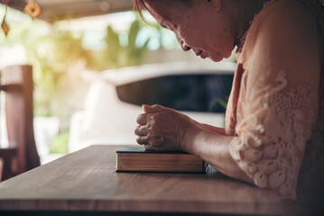 Prayer and bible concept. Asian senior woman praying, hope for peace the world and free from coronavirus, Hand in hand together, believes and faith in christian religion at church.