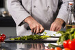 © stockbusters - Man hands cut food at kitchen. Closeup chef hands cutting vegetables with knife.