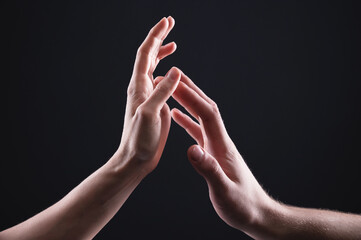 A close-up of two hands male and female gently touch each other. The concept tremulous rejection between the sexes