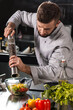 © stockbusters - Chef peppers salad at kitchen restaurant. Male professional pepper vegetables.