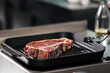© stockbusters - Raw steak lay at griddle pan. Closeup uncooked beef lay at pan.