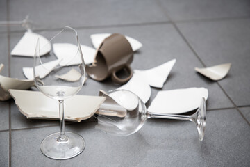 Broken Plate or broken water glass and dishes on the floor in the kitchen room The concept of accidents in the kitchen is dangerous for the body and young children inside the house.