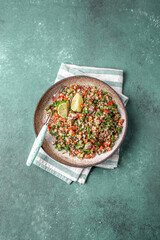 Wall Mural - Traditional Lebanese salad tabouli tabule with quinoa, herbs, tomatoes, mint and lemon