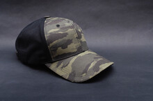 Men's Two-tone Cap On A Black Background. The Baseball Cap Is Black At The Back, Front And Visor Of The Military Workshop, Khaki Camouflage. Men's Black Cap With Camouflage In Macro. 