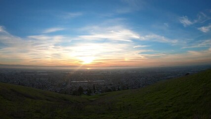 Wall Mural - Sunset time-lapse East San Francisco Bay Area; green hills visible in the foreground; Hayward, California