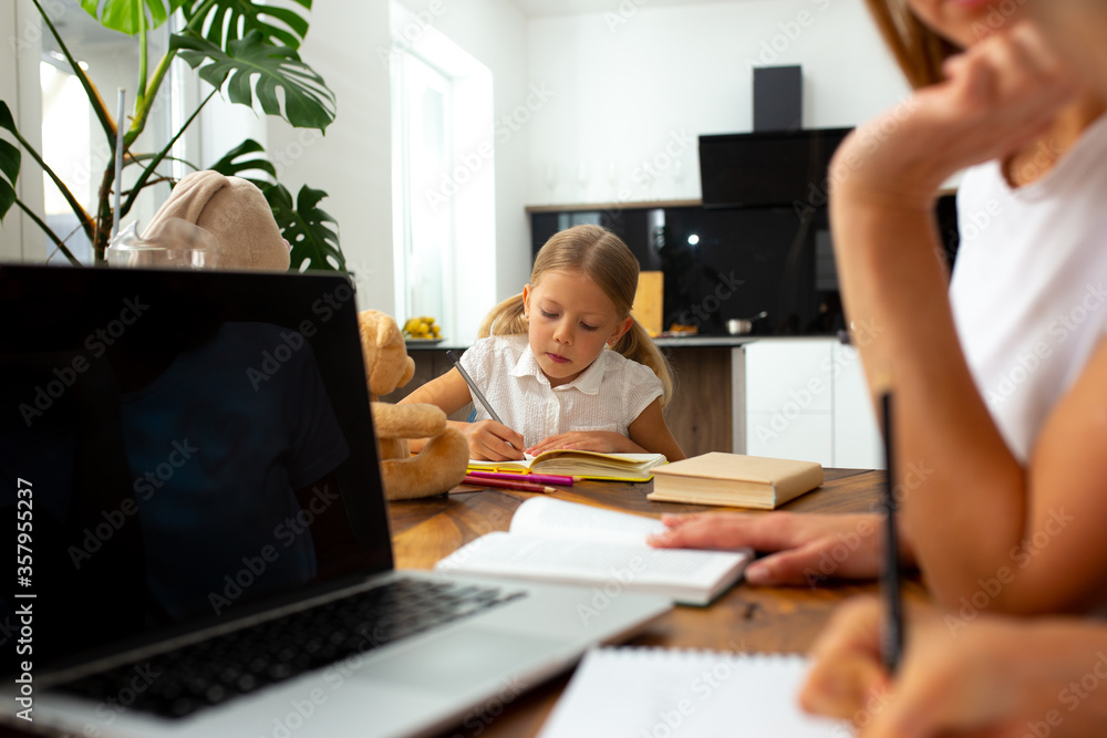Cute little girl studying with mother and sister at home - obrazy, fototapety, plakaty 