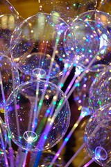 Wall Mural - Vertical shot of a clear bubble balloon luminous LED lights string with blurred background