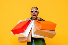 Beautiful Fashionable African American Woman With Colorful Shopping Bags In Surprised Sale Concept Isolated On Yellow Background