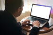 © canberk - Senior man in smart clothes using laptop on table at home blank screen copyspace
