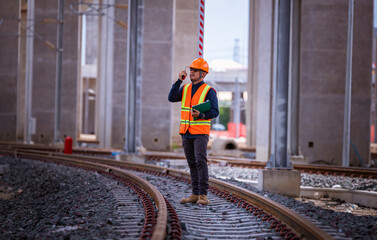 Wall Mural - Engineer under inspection and checking construction process railway switch and checking work on railroad station .Engineer wearing safety uniform and safety helmet in work.