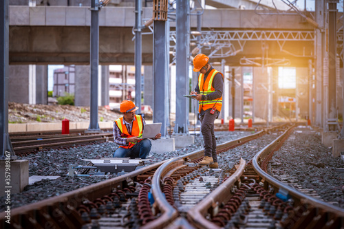 Fotografía Engineer under inspection and checking construction process railway switch and checking work on railroad station