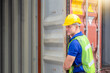 © JU.STOCKER - Foreman worker in hard hat and safety vest checking containers box from cargo