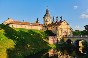 Wall Mural - Exterior of a medieval castle. View of an old castle with a fortress wall and a moat with water.