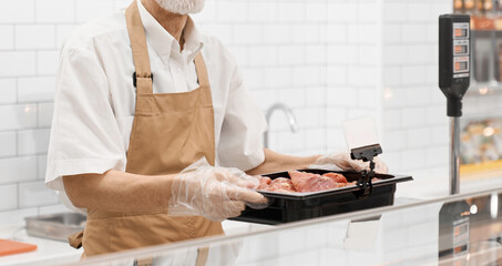 Wall Mural - Incognito male butcher demonstrating meat.